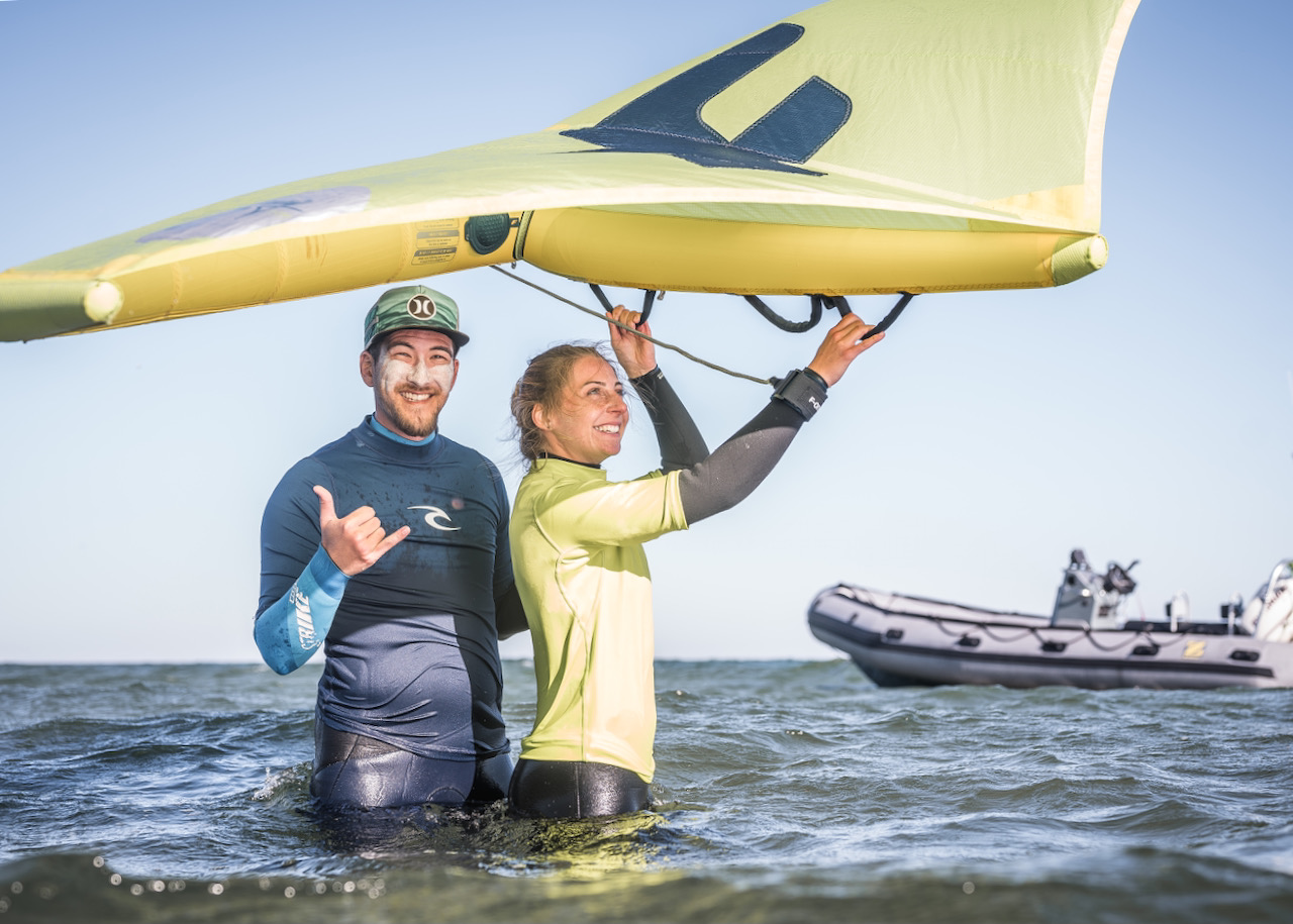 Wingfsurfer Einsteigerkurs am Binnensee mit dem Schulungsboot im Hintergrund