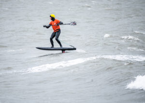 SUP Downwindfoiler auf Fehmarn mit einem Paddel in der Hand