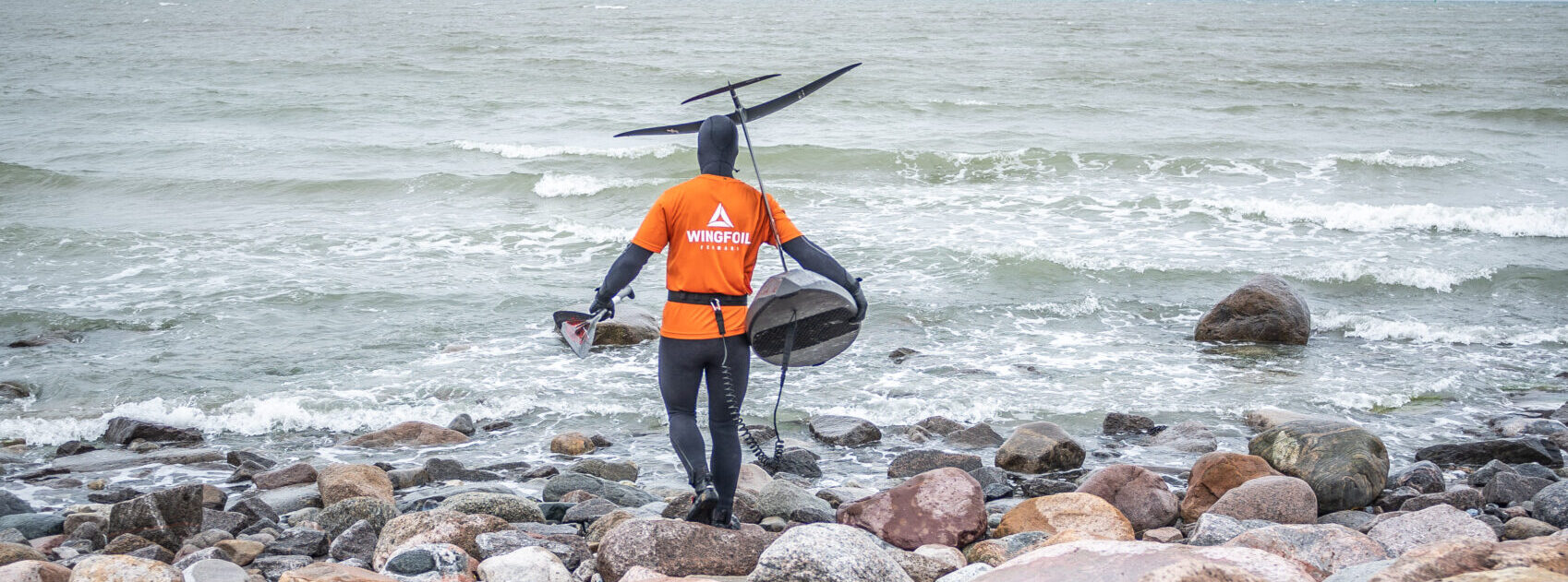 Basti auf dem Weg ins Wasser zum Downwindfoilen