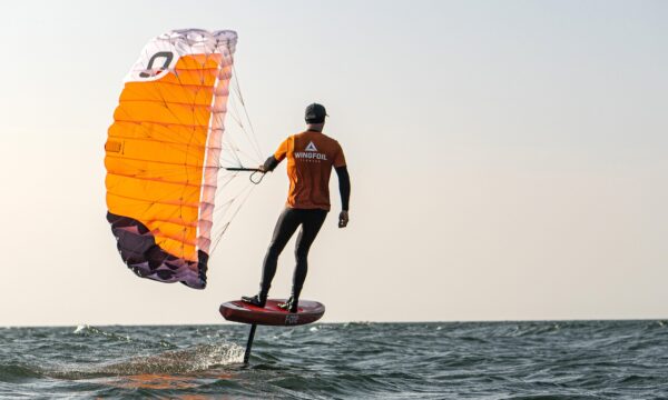 _1275527 Trainer mit dem Parawing und Foilboard fliegt über die Ostsee