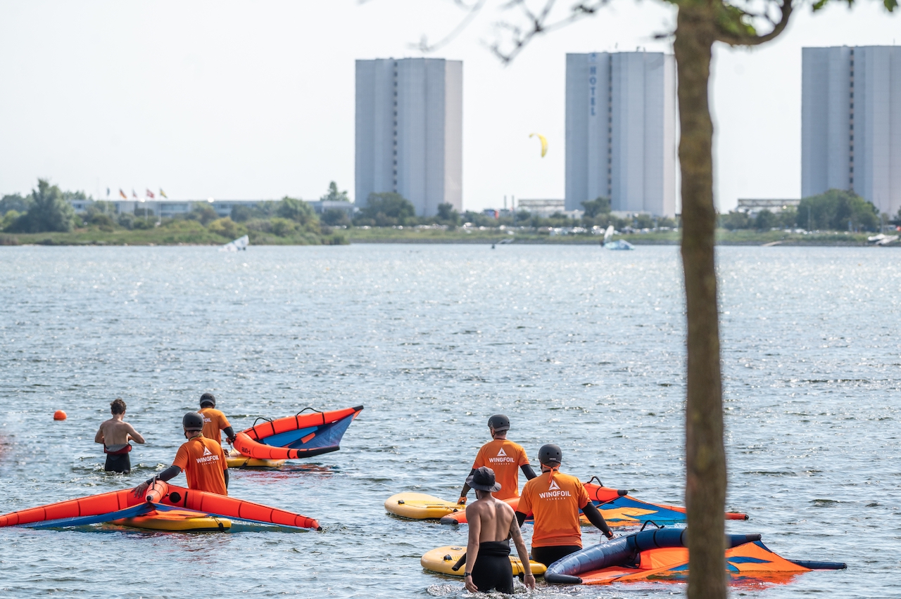 Wingsurf Schnupperkurs Teilnehmer stehen mit Surfmaterial im Wasser