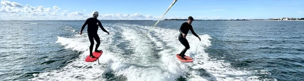 zwei foiler auf der Heckwelle surfen